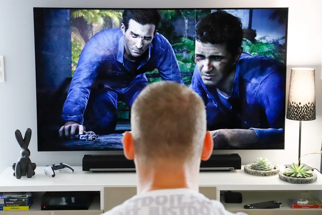 Mężczyzna oglądający telewizję w salonie - wpływ mediów na podświadomość