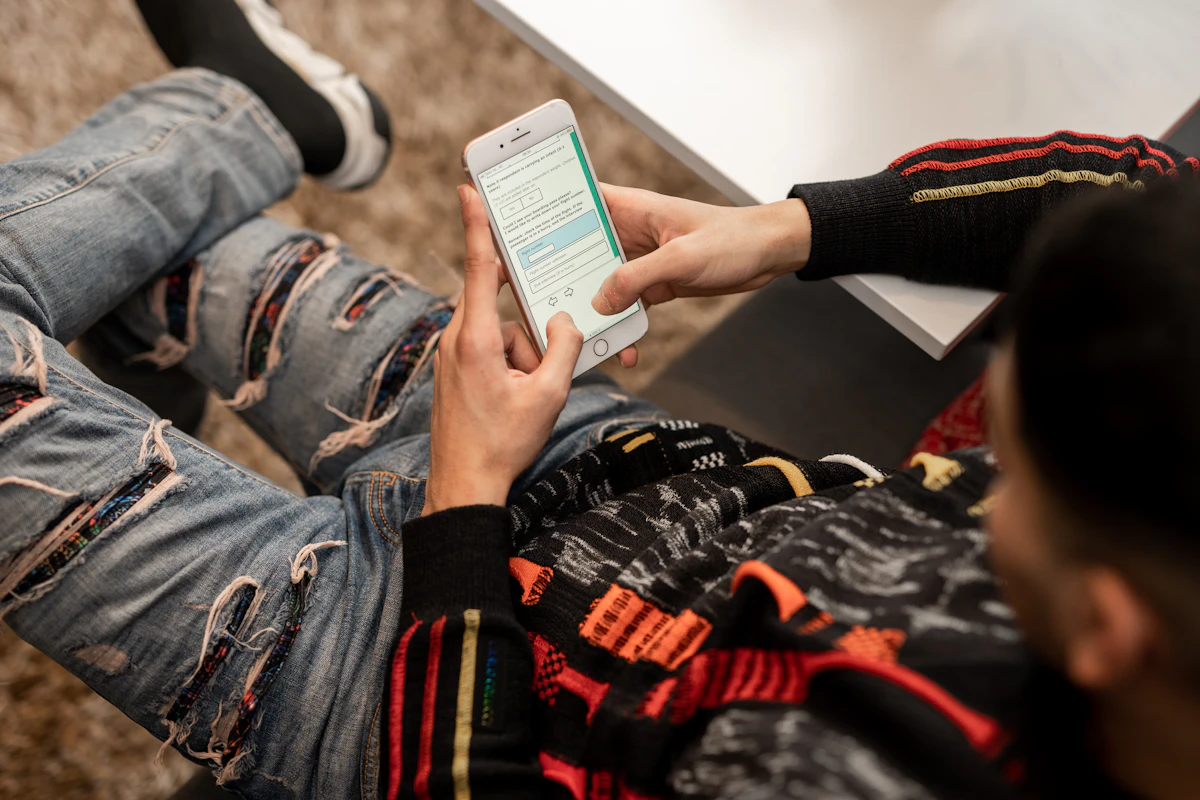 Nastolatek siedzacy na podlodze korzystajacy z telefonu - cyfrowa samotnosc adolescenta